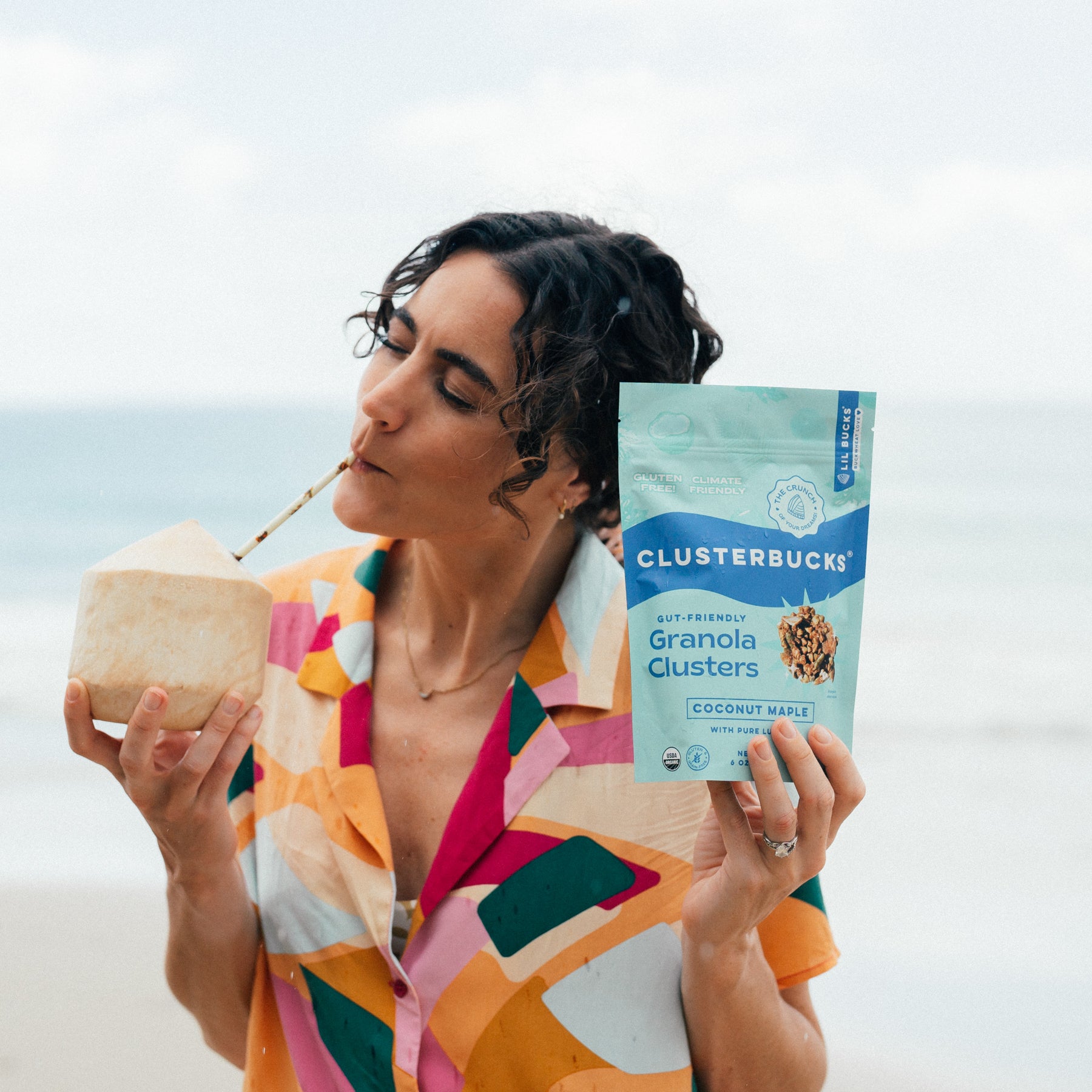 girl sipping coconut and coconut maple clusterbucks granola bites